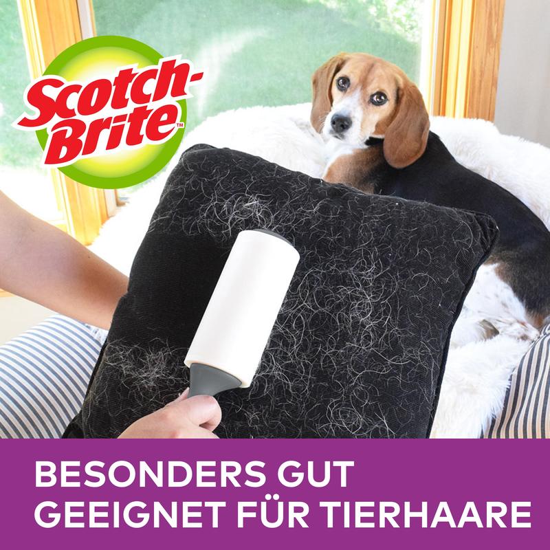 Egy személy használja a Scotch-Brite™ Pet Extra Sticky* hengert az állatszőr eltávolítására (48 lap, 1 darab) a 3M Deutschland GmbH-tól, hogy eltávolítsa az állatszőrt egy fekete párnáról. Egy kutya fekszik a kanapén; a logó és a "KÜLÖNÖSEN ALKALMAS ÁLLATSZŐRRE" jelenik meg felette.
