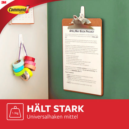 An einer grünen Wand hängt ein Klemmbrett mit einem bedruckten Blatt mit 3M Deutschland GmbH Mittelgroße Command™ Mehrzweckhaken M im Vorteilspack, 17001-2. In der Nähe hängen mehrere Rollen Klebeband. Das Bild zeigt deutschen Text und das 3M Command-Logo.
