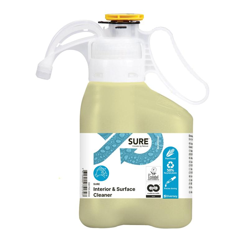 Egy világossárga SURE Interior & Surface Cleaner általános tisztítószer a Diversey Deutschland GmbH & Co. OHG-tól egy fogható műanyag palackban mérőkupakkal; környezetbarátként címkézve növényi összetevőkkel, ökoszimbólumokkal és használati utasításokkal.