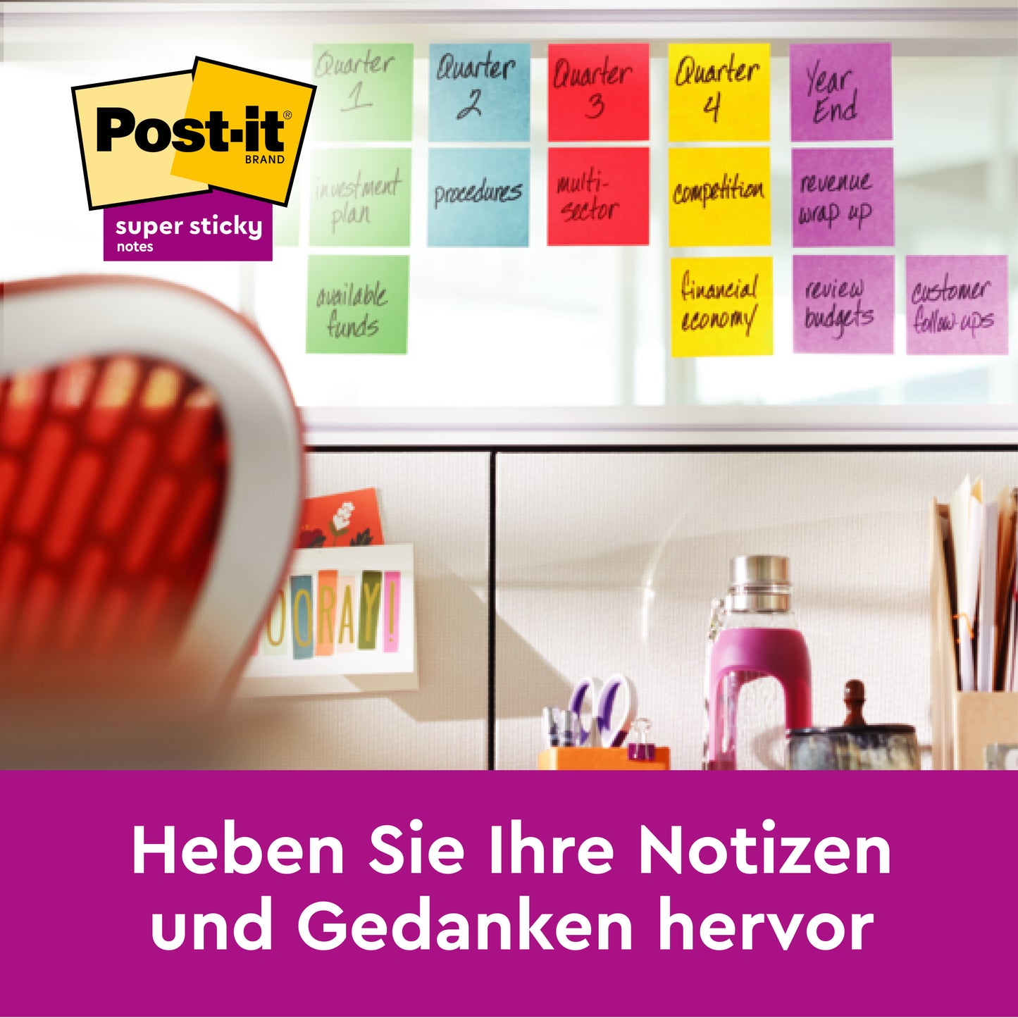 Egy íróasztal fölött színes Post-it® Super Sticky 100 % újrahasznosított jegyzettömbök (76 mm x 76 mm, 70 lap/blokk, 100% PEFC) a 3M Deutschland GmbH-tól üzleti témákat mutatnak be. A német szöveg így szól: "Emelje ki jegyzeteit és gondolatait.