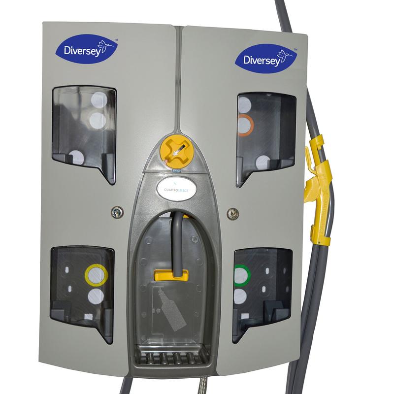 Die Quattro Select Uni AirGap Dosierstation von Diversey Deutschland GmbH & Co. OHG egy szürke fali készülék, amely akár 4 terméket is kezelhet, négy látható rekesszel, átlátszó lemezekkel, csatlakoztatott csövekkel, kompakt kialakítással, forgatógombbal és karral.