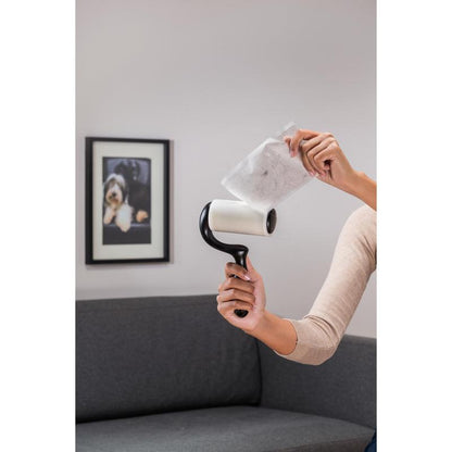 Egy személy egy használt lapot húz le a 3M Deutschland GmbH Scotch-Brite™ Everyday Clean szöszeltávolító lapos felületekre (56 lap, 1/csomag) termékről, miközben egy szürke kanapé és egy kutyás fénykép előtt áll - ideális lapos felületek tisztítására.