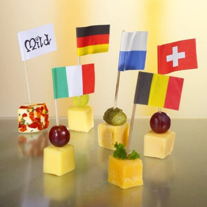 Hat sajtkocka szőlővel vagy fűszernövényekkel van díszítve, és a PAPSTAR GmbH 8 cm-es fehér dekorációs pálcikáival van dekorálva, minden kis zászlón ez áll: „Mild”, Németország, Olaszország, Finnország, Svájc vagy Belgium.