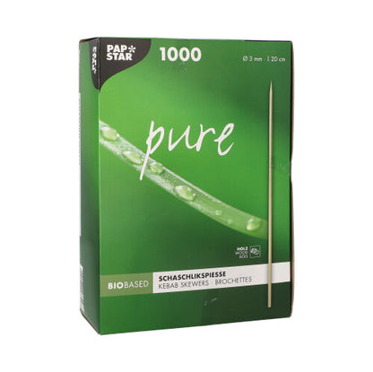 Egy zöld doboz "PAPSTAR Sasliknyársak fa pure" felirattal (Ø 3 mm, 20 cm, 1000 darab) a PAPSTAR GmbH-tól, amelyen egy nyárs és egy friss zöld növény közeli képe látható.