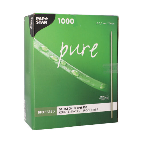 Egy zöld doboz a "PAPSTAR fából készült sasliknyárs 'pure', Ø 3,5 mm, 20 cm hosszú | papírtálca (1000 darab)" felirattal a PAPSTAR GmbH-tól 1000 fa nyársat tartalmaz, és egy nyárs képet mutat vízcseppekkel élénkzöld háttéren.