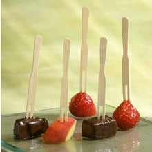 Öt PAPSTAR fingerfood nyárs "pure" (8,5 cm) a PAPSTAR GmbH-tól, melyeken két eper, két csokikocka és egy almaszelet van feltűzve, amelyek egy poháron állnak világoszöld háttér előtt.