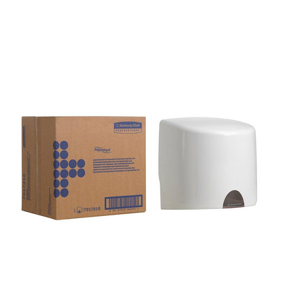 Egy doboz "Kimberly-Clark GmbH" felirattal egy fehér Aquarius™ törlőkendő-adagoló mellett áll - központi adagolás, ideális a higiénikus kendőkivételhez, egyszerű fehér háttér előtt.