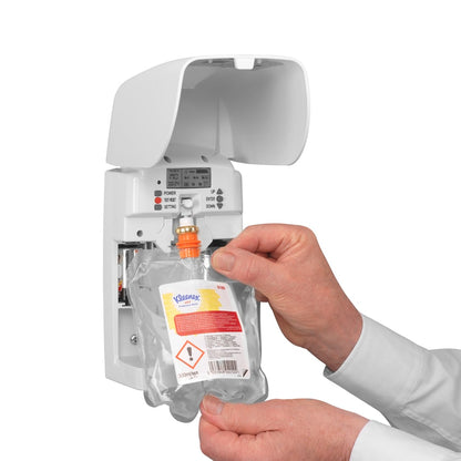 Egy személy behelyez egy 300 ml-es átlátszó Kleenex® Duft Joy utántöltő csomagot a Kimberly-Clark GmbH-tól egy fehér fali adagolóba, és a látható gombokkal és jelzőfényekkel hosszú távú frissességet biztosít.