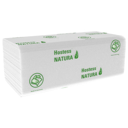Egy halom fehér, hajtogatott Hostess™ NATURA™ kéztörlő (Kimberly-Clark GmbH), Nagy, 20 x 84 lap, zöld márkajelzéssel és hüvelykujj felfelé szimbólummal. Németországban készült - ideális papírtörlő nyilvános helyekre. 20 csomag dobozonként.