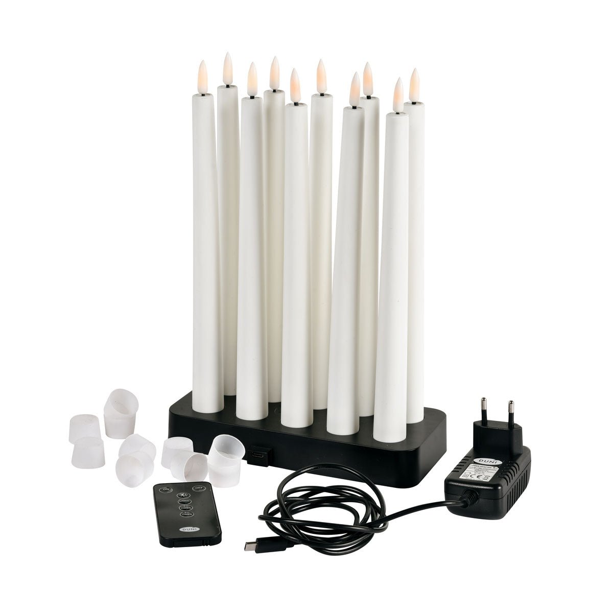 Egy 1 darabos Duni GmbH LED-es kúpos gyertya 27,8 cm meleg fehér színben elegánsan van bemutatva fekete töltőállomással, távirányítóval, adapterrel, USB-kábellel és fehér sapkákkal - tökéletes egy stílusos otthoni dekorációhoz.