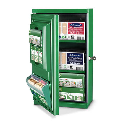Az Orkla Wound Care AB zöld Cederroth elsősegély-szekrény Mini (fém) (Sz 260 x M 440 x M 170mm) nyitva van, kulccsal a zárban és rendezett kötszercsomagokkal, sebtapaszokkal és elsősegély-anyagokkal a polcain.