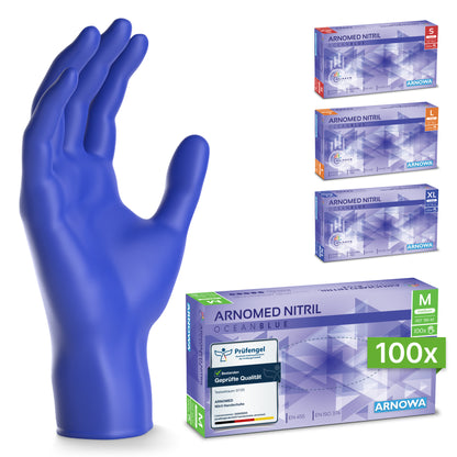 Egy kék ARNOMED NITRIL OCEAN BLUE egyszer használatos kesztyű az ARNOWA GmbH-tól egyenesen áll négy karton mellett, S, M (latexmentes, elöl), L és XL méretekben. Mindegyik nitril sötétkék anyagból készült.