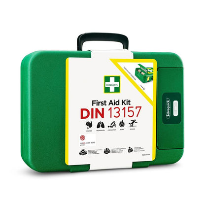 A zöld elsősegélydoboz DIN | Csomag (1 darab) műanyagból az Orkla Wound Care AB-től fehér címkével rendelkezik a "First Aid Kit DIN 13157" felirattal, ikonikus szimbólumokkal, és elengedhetetlen vészhelyzeti felszerelés.