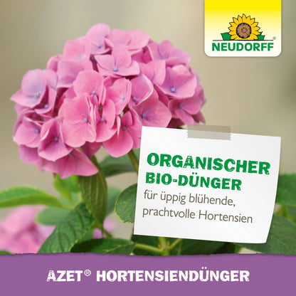 Rózsaszín hortenzia zöld levelekkel. Egy címkén az áll: "Organikus speciális trágya a buján virágzó, pompás hortenziákért". Neudorff Shop logó (napraforgó) jobb felső sarokban. Szöveg alul: "Azet HortensienDünger folyékony".