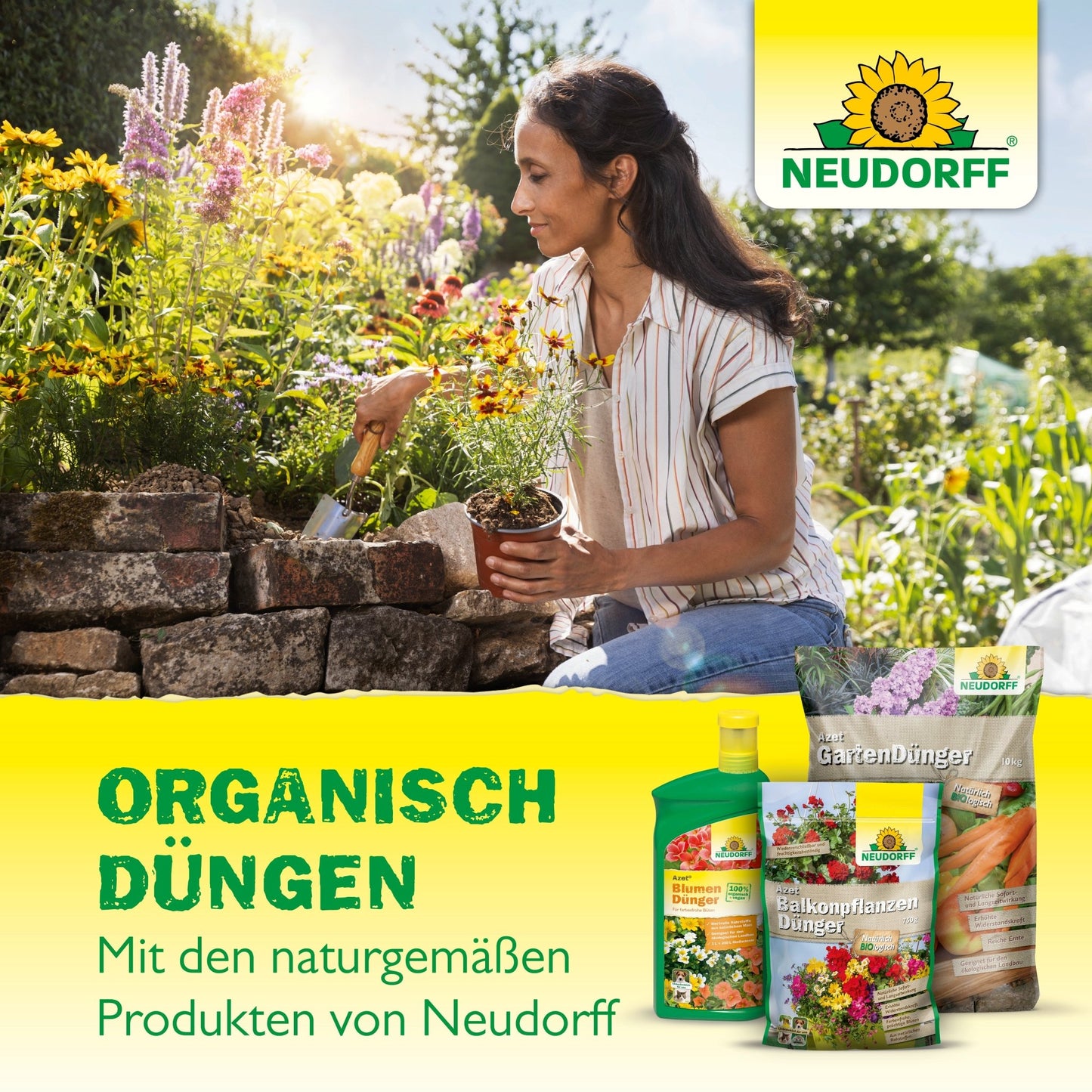 Egy nő egy kőből készült kerti ágyásnál guggol és hortenziákat ültet. Az előtérben az Azet HortensienDünger folyékony és más Neudorff Shop termékek vannak kiállítva. A német szöveg ezzel az organikus trágyával történő organikus trágyázást reklámozza.