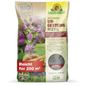 Ein 20-kg-Sack Neudorffs UrgesteinsMehl aus dem Neudorff Shop, abgebildet mit violetten Blumen, Möhren und Bodenbildern. Der Sack mit der deutschen Aufschrift deckt 200 m² ab und enthält Mineralpulver für die Verwendung im Boden.
