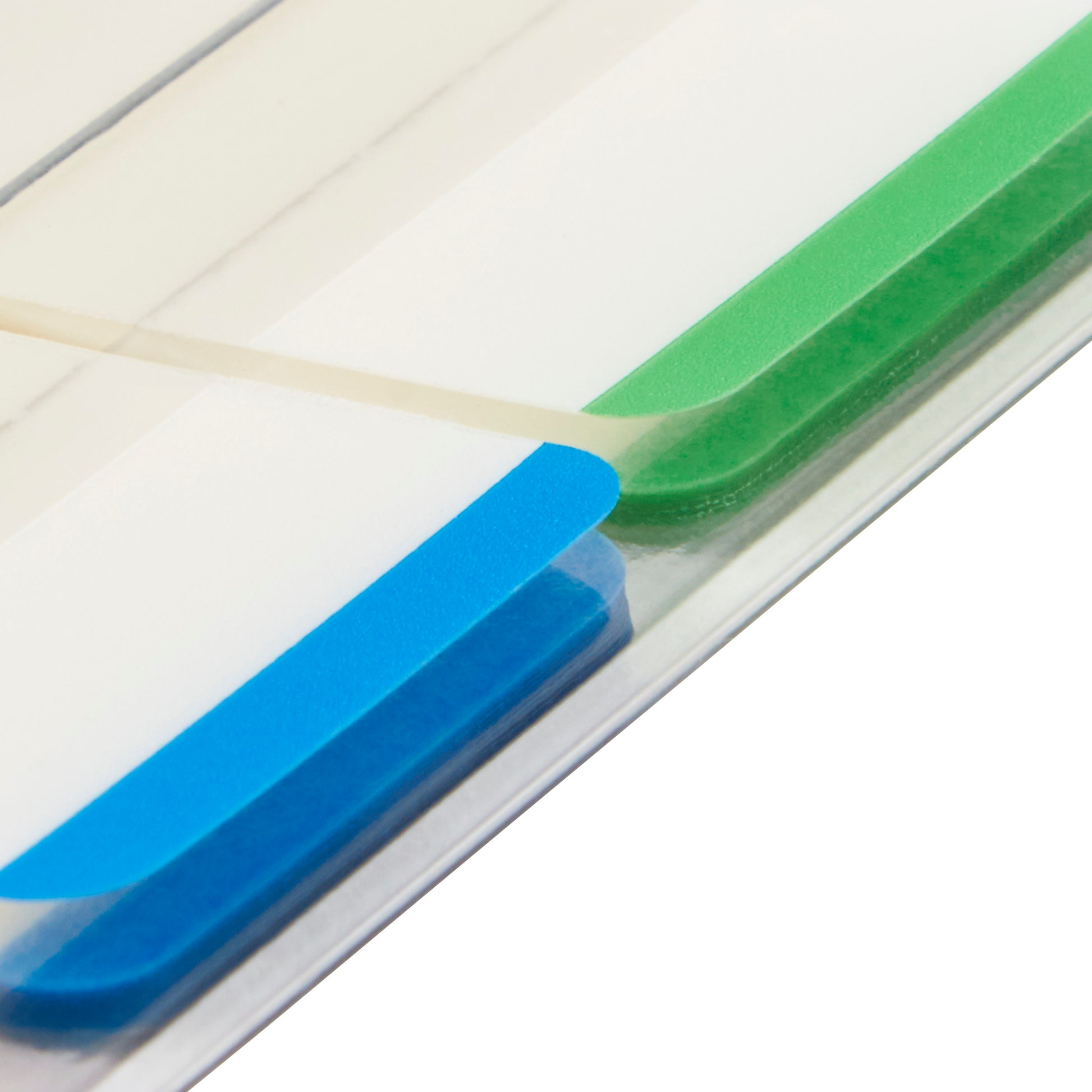 Nahaufnahme einer Aktenmappe mit zwei Post-it® Index Strong Ablagetabs von 3M Deutschland GmbH - ein blauer und ein grüner, jeweils 25,4 x 38,1 mm -, die durch eine transparente Folie getrennt sind. Die erhabenen Tabs sind schräg sichtbar.