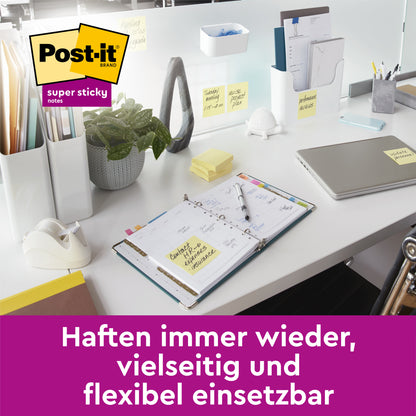 Egy rendezett fehér íróasztal laptoppal, jegyzetfüzettel és növénnyel, amelyre 3M Deutschland GmbH Post-it® Super Sticky Notes, sárga (76 mm x 76 mm) van rögzítve. Német szöveg: "Újra és újra tapad, sokoldalúan és rugalmasan használható."