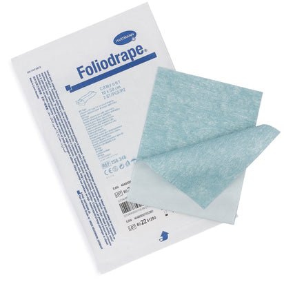 Egy csomag Paul Hartmann AG Foliodrape műtéti ragasztószalag 10x50 (csomag, 115 darab) fekszik két kék-fehér, hajtogatás nélküli kendő mellett, amelyek a műtéti takarók rögzítésére szolgálnak steril műtéti környezetben.