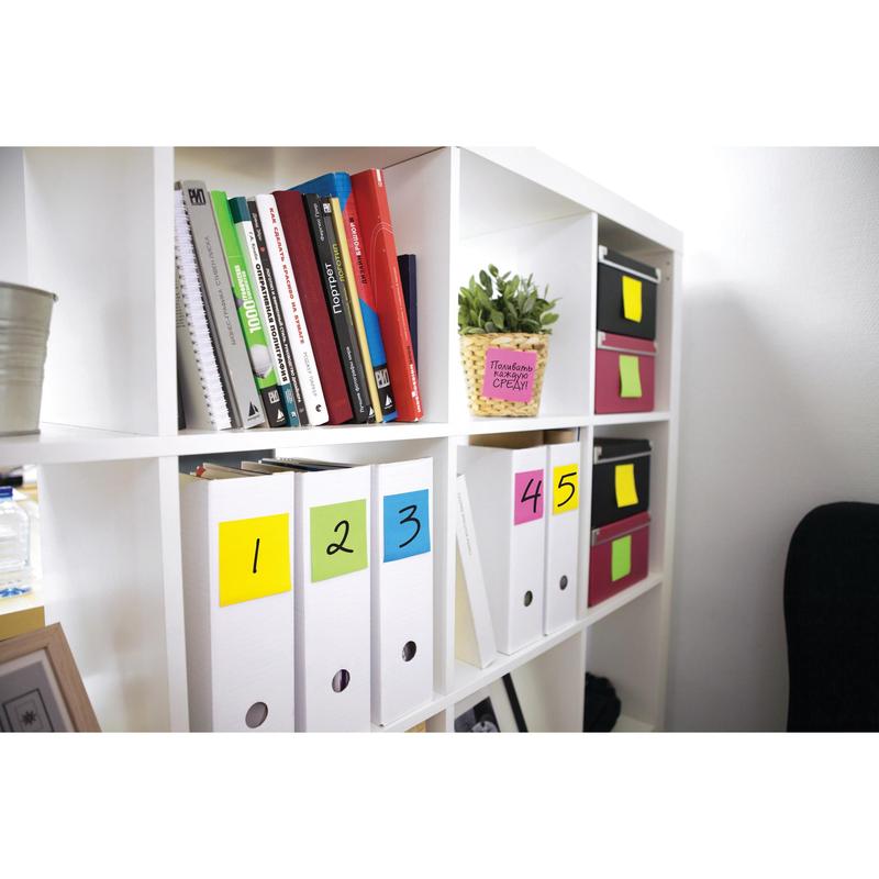 Egy fehér könyvespolc mappákat tartalmaz színes számokkal 1-5, könyveket, kis dobozokat és egy cserepes növényt. Post-it® jegyzetlapok különböző neon színekben (3M Deutschland GmbH) vannak rögzítve dobozokra és mappákra, megkönnyítve a szervezést.