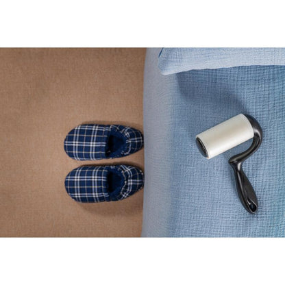 Egy pár kék kockás papucs áll egy bézs szőnyegen, egy világoskék takaróval borított ágy mellett, miközben a 3M Deutschland GmbH Scotch-Brite™ Everyday Clean szöszeltávolító lapos felületekre (56 lap, 1/csomag) az ágyon fekszik és használatra kész.