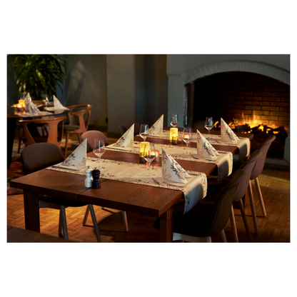 Egy hangulatos étkező két faasztallal rendelkezik, amelyeken borospoharak és Duni Bio Dunisoft® szalvéták találhatók pislákoló gyertyák mellett. Sötét székek veszik körül az asztalokat, amelyeket egy égő kandalló tesz hangulatosabbá. Plüss ülőalkalmatosságok és egy növény járulnak hozzá a természet ihlette dizájnhoz.