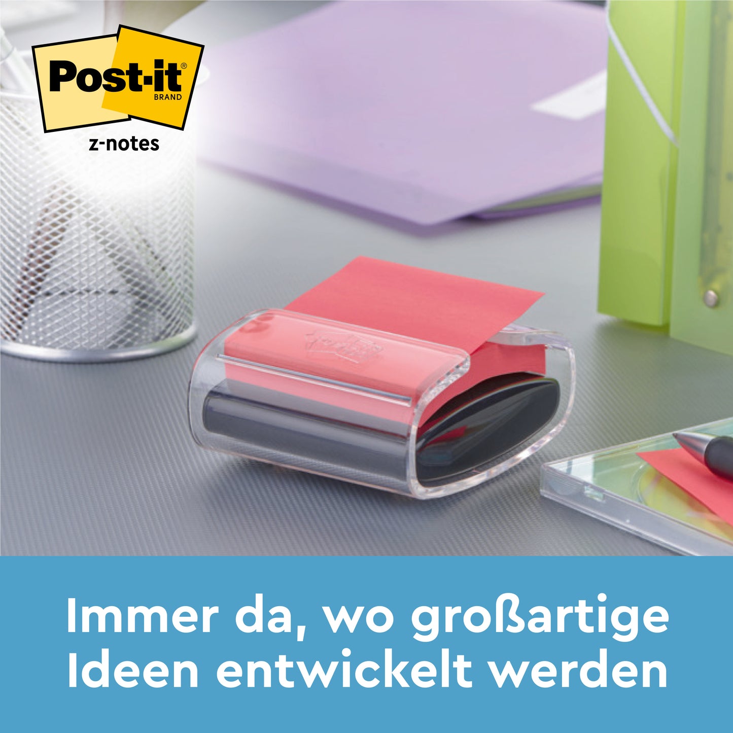 Egy medve alakú, fehér Post-it® Z-Notes adagoló kék Super Sticky Z-Notes jegyzettömbökkel (76 x 76 mm) a 3M-től egy íróasztalon áll tollak és mappák mellett. Alul a szöveg: "Mindig ott, ahol nagyszerű ötletek születnek."