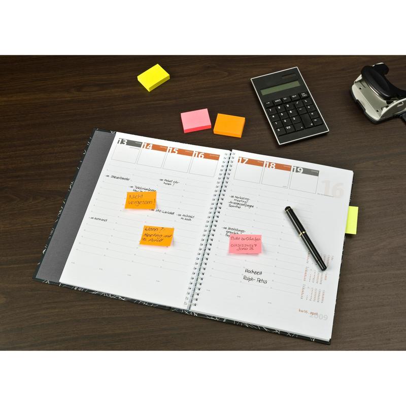 Egy nyitott tervező kézzel írt jegyzetekkel és különböző neon színű Post-it® jegyzetlapokkal (38 mm x 51 mm, 100 lap/blokk, 3 blokk/csomag, 100% PEFC) a 3M Deutschland GmbH-tól egy fából készült asztalon tollal, számológéppel és ragasztószalag adagolóval.