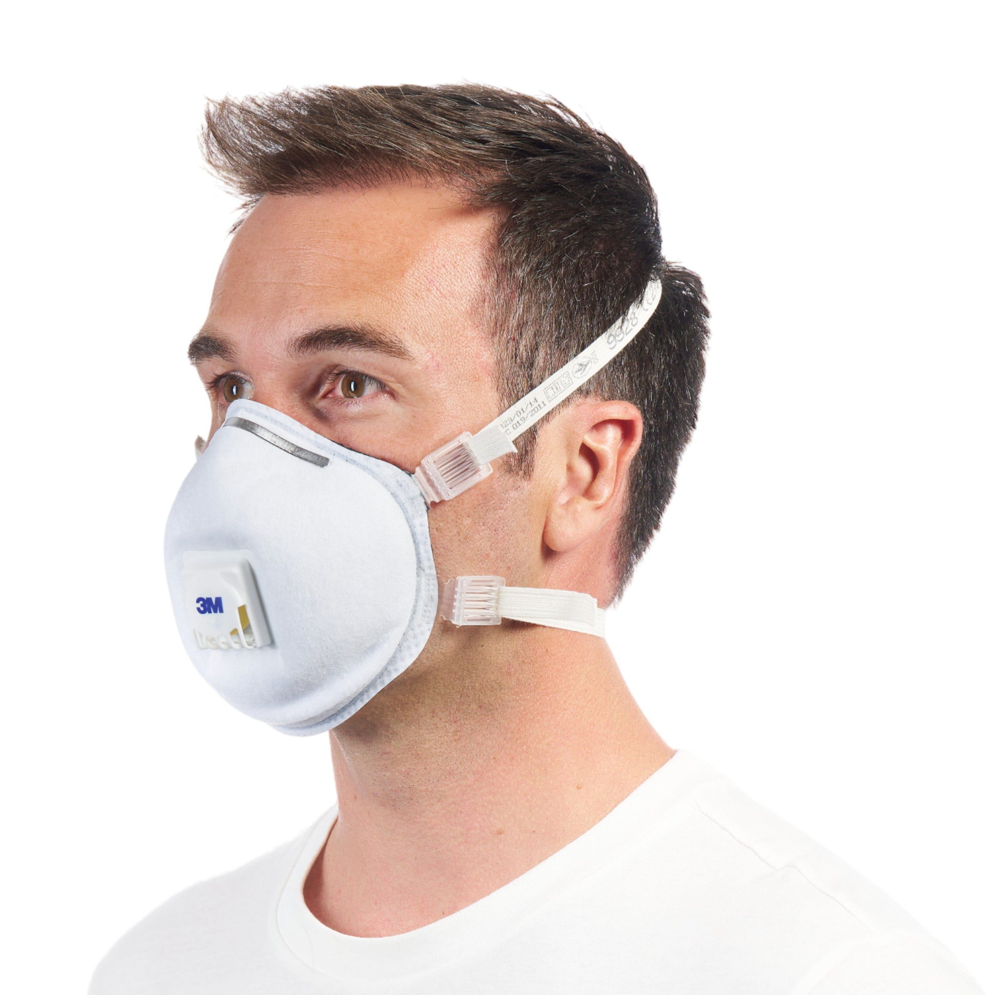 Ein Mann mit kurzen braunen Haaren trägt die 3M™ Cool Flow™ Partikelmaske 9928 für Schweißarbeiten, mit Ventil von 3M Deutschland GmbH, in der Seitenansicht vor einem schlichten weißen Hintergrund.