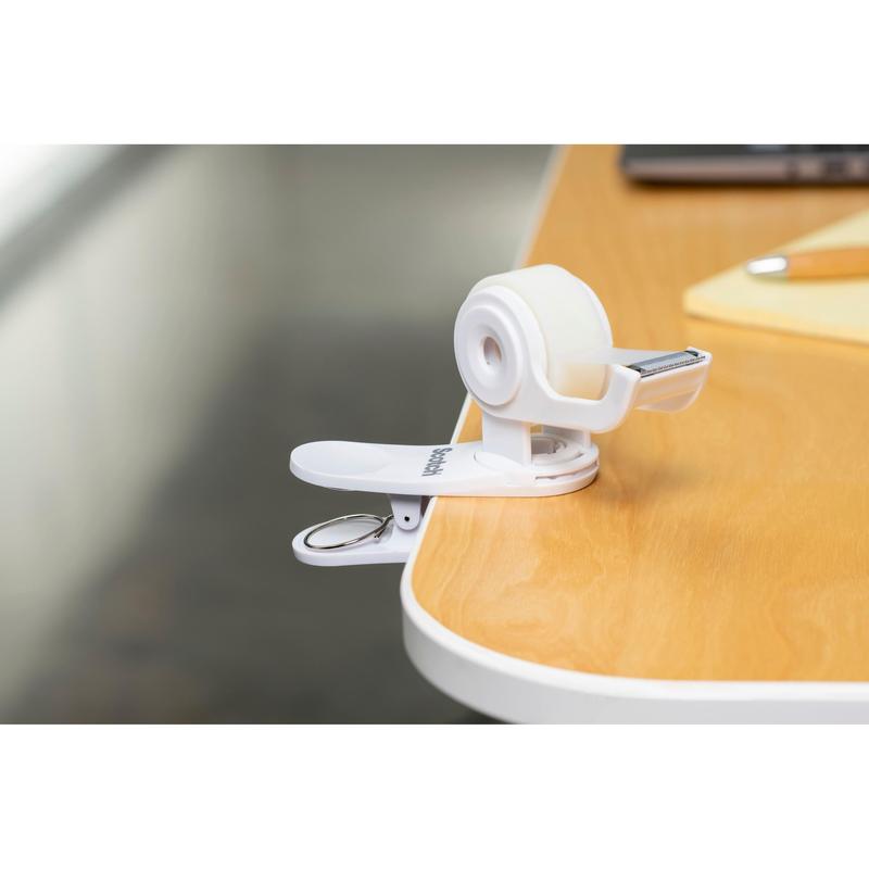 A 3M Deutschland GmbH Scotch™ Clip & Twist ragasztószalag-adagoló C19 Scotch® Magic™ Láthatatlan ragasztószalaggal (19 mm × 8,89 m) egy jegyzetfüzet és egy toll mellett van egy fa asztalhoz rögzítve.