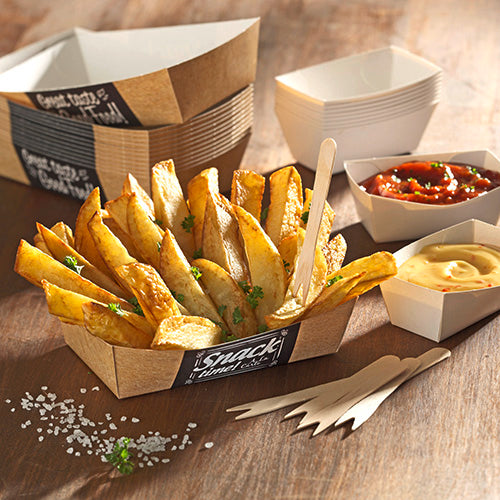 Serviert werden Kartoffelecken in PAPSTAR 50 Pommes-Frites-Schalen „pure“ (3,5 x 7 cm) der PAPSTAR GmbH, garniert mit Petersilie, neben Holzgabeln, Meersalz und zwei eckigen Schalen mit Salsa und gelbem Dip auf einem Holztisch.