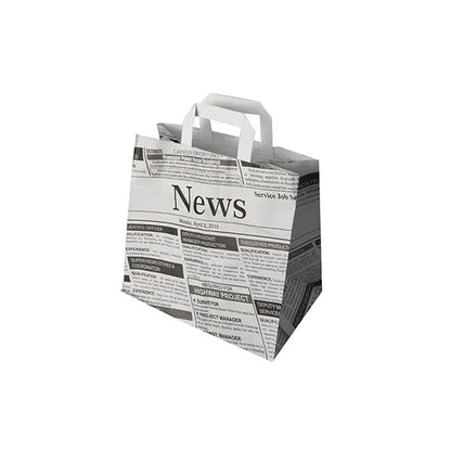 A PAPSTAR 50 hordtáska a PAPSTAR GmbH-tól környezetbarát papírzacskók fogantyúkkal, amelyek fekete-fehér újságmintát mutatnak címsorokkal és cikkekkel fehér alapon.