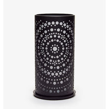 Eine schwarze zylindrische Vase mit kreisförmigen Perforationen in konzentrischen Kreisen, die ein symmetrisches Design erzeugen, das an modernes Design erinnert, ähnlich dem Duni Kerzenhalter Billy Metall von Duni GmbH, steht vor einem schlichten weißen Hintergrund.