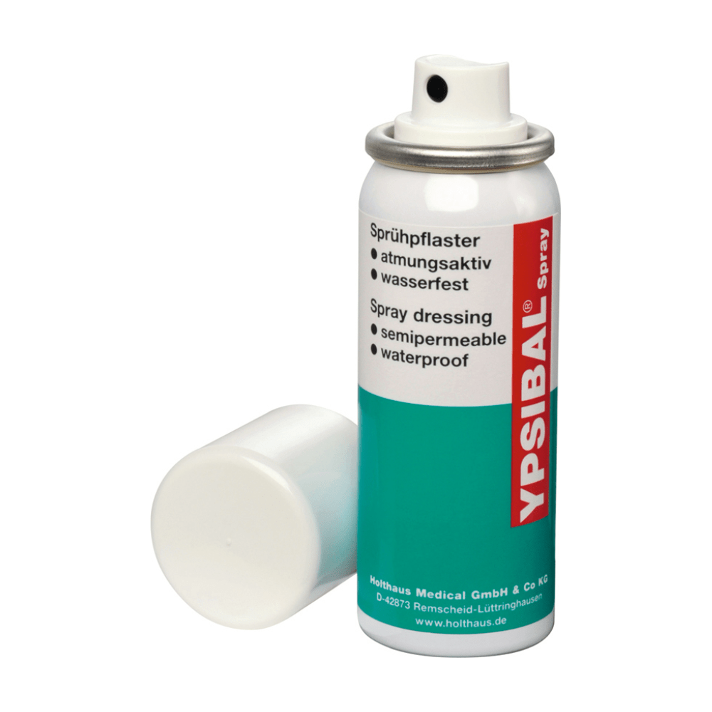 A Holthaus Medical GmbH & Co. KG gyártmányú Holthaus Ypsibal® Spray aeroszolos flakon – 50 ml – fehér kupak nélkül van kiállítva, és az aljára támaszkodik. A túlnyomórészt fehér, kék-zöld részekkel és piros díszítéssel ellátott flakonon szereplő szöveg arra utal, hogy ez egy félig áteresztő, vízálló, lélegző spray-kötés vágási és horzsolási sebek kezelésére.