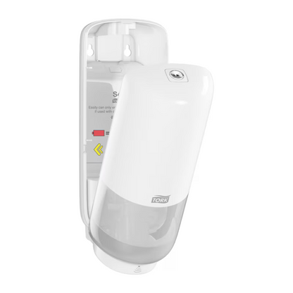A falra szerelhető Tork 561600 bőrápoló adagoló Intuition Sensor Elevation S4 a TORK - Essity Professional Hygiene Germany GmbH-tól nyitott elülső fedéllel rendelkezik fehér színben. Az átlátszó alsó rész lehetővé teszi a szappantartály megtekintését, míg a nyitott belső részben telepítési és utántöltési utasítások, valamint nyilak láthatók, amelyek biztosítják az érintésmentes adagoló funkció egyszerű karbantartását.