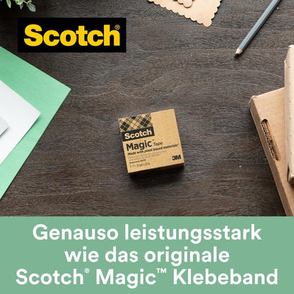 Egy doboz Scotch® Magic™ ragasztószalag a 3M Deutschland GmbH-tól (19 mm x 33 m, 9 tekercs/csomag, 66% növényi alapú ragasztóval) egy faasztalon fekszik zöld és fehér papírok, egy jegyzetfüzet és egy toll mellett - tökéletes a környezettudatos irodai szükségletekhez.