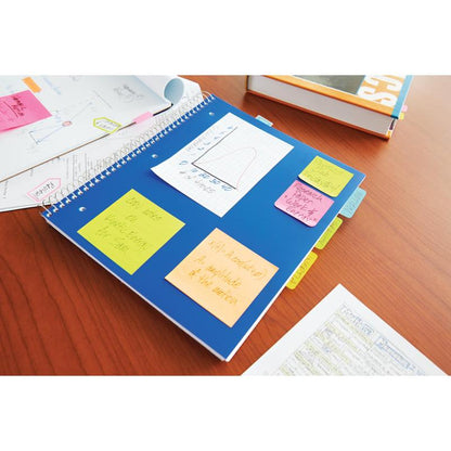 Egy kék spirálfüzet különböző neon színű 3M Deutschland GmbH Post-it® jegyzetlapokkal (38x51 mm, 100 lap/blokk, 3 blokk/csomag) egy fából készült asztalon fekszik, papírok és egy iskolai könyv mellett.