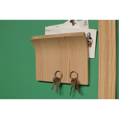 Ein hölzerner Wandbriefkasten mit Haken für Schlüssel wird mit dem Scotch-FIX™ Doppelseitigen Innenmontageband der 3M Deutschland GmbH an einer grünen Wand befestigt.