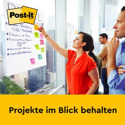 Eine Frau zeigt auf ein großes Blatt mit Notizen an der Wand - wahrscheinlich eine Post-it® Super Sticky selbsthaftendes Recycling Meeting Chart 559RP (63,5 x 76,2 cm), 30 Blatt/Block, von 3M Deutschland GmbH. "Projekte im Blick behalten" steht auf dem Bild.