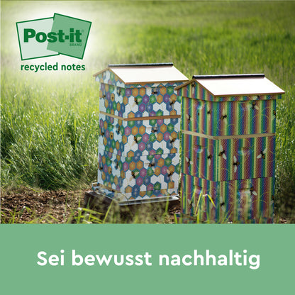 Auf einer Wiese stehen zwei bunte Bienenstöcke unter dem Logo von Post-it® Recycling Notes (76 mm x 76 mm, 100 Blatt/Block, 100% PEFC, 3M Deutschland GmbH). Der Text darunter lautet "Sei bewusst nachhaltig".