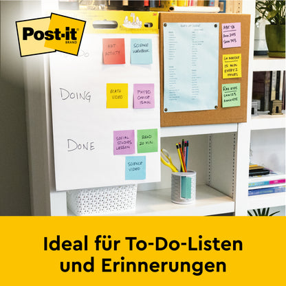 Auf einem Schreibtisch liegt das Post-it® Super Sticky selbsthaftendes Mini Meeting Chart, 38x45,7cm, von 3M Deutschland GmbH, mit einer bunten To-Do-Liste. In der Nähe liegt ein blauer Terminkalender und Bücher füllen das Regal darunter. Text: "Ideal für To-Do-Listen und Erinnerungen.