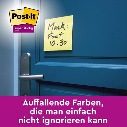 Egy 3M Deutschland GmbH Post-it® Super Sticky Notes kocka sárga (76 x 76 mm) kézzel írt "Mark: Foot 10.30" felirattal egy kék ajtóra ragasztva a kilincs felett; logó bal felső sarokban, német szöveg alul lila színben.