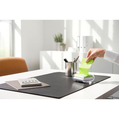 Egy személy kihúz egy sárga Post-it® Super Sticky Z-Note (76 x 76 mm) jegyzetet a 3M Deutschland GmbH fekete PRO Post-it® Z-Notes Dispenseréből, egy rendezett íróasztalon, számológéppel, tolltartóval és fekete alátéttel, világos nappali fényben.